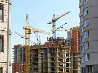 Construction site background. Cranes and buildings under construction.