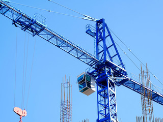 Huge crane against blue sky. Hoisting crane. Construction site. Wallpaper.