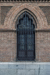 Fototapeta na wymiar Ventana gótica/ventana neogótica en una fachada de ladrillo de un edificio religioso en Madrid. España.