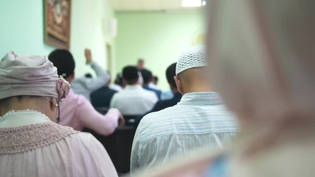 Muslim people sitting on armchairs at the islamic mass rally
