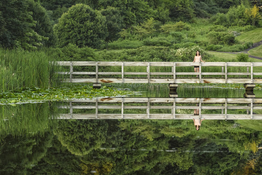 Reflections, wooden bridge and girl