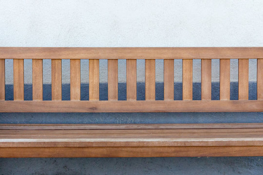 Empty wooden banch against wall. Outdoor furniture. Relax and rest concept. Patio design.