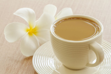 Cup Of Coffee With Frangipani (Plumeria) Flower On Table In Morning.