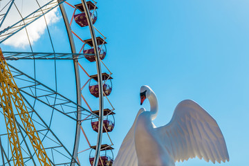 Amusement park. Ferris wheel and plastic swan close up