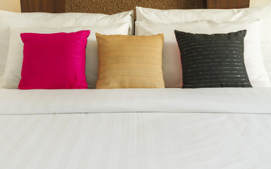 Close up of a white bed and pillows with lamp light, Vintage style.