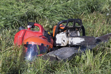 Chainsaw and protective helmet of lumberjack lie on sawn wood. concept is to cut trees at altitude.
