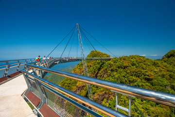 Tourists walking on the Langkawi Sky Bridge, a curved pedestrian cable-stayed bridge, suspended by cables from a single pylon, at the peak of Gunung Mat Chinchang on Langkawi Island, Kedah, Malaysia.
