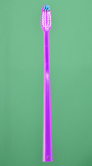 Pink toothbrush on pastel background.