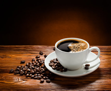 Coffee cup and coffee beans on  wooden background