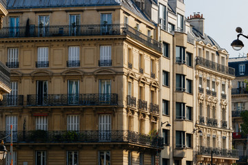 Fototapeta na wymiar Paris residential buildings. Old Paris architecture, beautiful facades, typical french houses on sunny day. Famous travel destinations in Europe. City life, lifestyle and expensive real estate concept