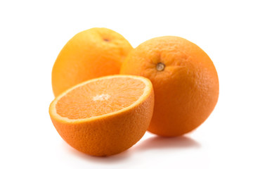 close up view of wholesome oranges with cut piece isolated on white