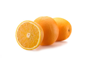 close up view of wholesome oranges with cut piece isolated on white