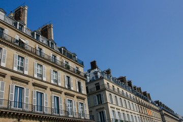 Fototapeta na wymiar Paris residential buildings. Old Paris architecture, beautiful facades, typical french houses on sunny day. Famous travel destinations in Europe. City life, lifestyle and expensive real estate concept