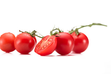 close up view of ripe cherry tomatoes on twig isolated on white