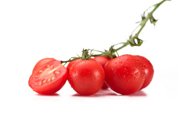 close up view of fresh cherry tomatoes on twig isolated on white