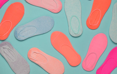 Many colored socks on a blue pastel background. Minimalism. Top View.