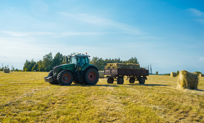 Fototapeta premium tractor on the field with hay