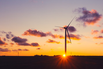 Obraz premium Wind turbines for electrical power generation in Normandy, France. Countryside and industrial landscape at sunset. Renewable energy sources. Environment friendly energy production