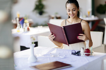 Beautiful woman ordering from menu