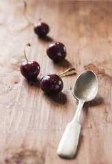 Cherries on wooden table with water drops macro background