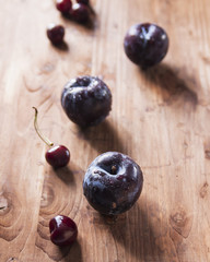 Natural organic blue plums on wooden table. Farmers fruits still life photography, selective focus beautiful bokeh.
