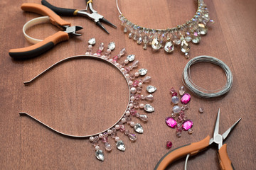 The process of creating jewelry from wire and crystals. Working tools on the table. Handmade...