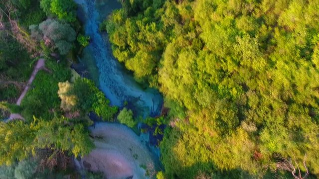 Aerial. The Blue Eye (Albanian: Syri i Kalter, is a water spring near Muzine in Vlore County, southern Albania. A popular tourist attraction. Mountains and river footage.