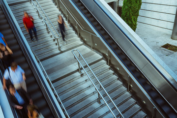 People on stairs and moving escalator at the interchange station near business and commercial center in Paris. Urban scene, city life, public transport hub and traffic concept. Blurred background - 212097955