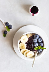 Porridge in a bowl with blueberries, banana and mint. Healthy breakfast concept
