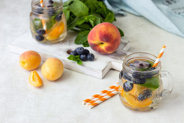 Lemonade of  apricot, blueberry and fresh mint in jars. Summer cold drink.