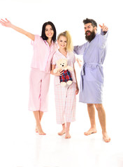 Man with beard and mustache, cute blonde and brunette girls with toy bear full of energy. Girls with bearded macho in pajamas and robe in morning, isolated white background. Good mood concept.
