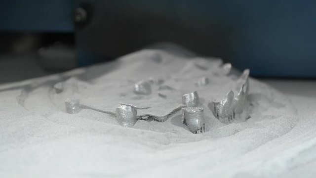 Lower down printing platform with object printed on 3d printer for metal and covered metallic powder. 3D printer printing metal. Laser sintering machine for metal Progressive DMLS, SLM, SLS technology