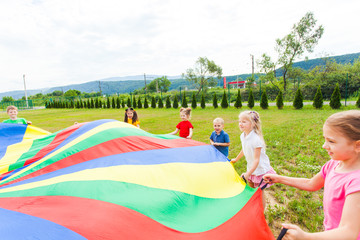 Rainbow parachute held by children