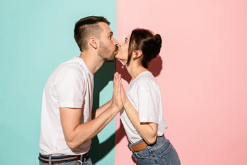 A view of a loving couple kissing on blue and pink background
