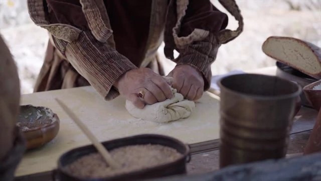 Medieval. A man bake a baking dish to make bread. Medieval Reenactment