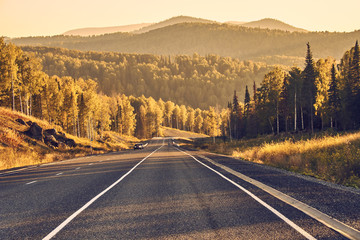 Panorama of mountain road on autumn sunset background 
