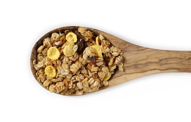 Crunchy granola, muesli pile with wooden spoon isolated on white, top view