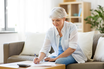 business, savings, annuity insurance, age and people concept - senior woman with papers or bills...
