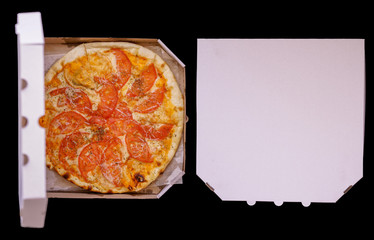 Pizza in a cardboard box against a dark background. Space for text. View from above. Pizza delivery.