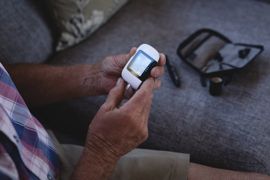 Senior Man Checking His Blood Sugar With Glucometer