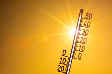 Hot summer or heat wave background, bright sun with thermometer