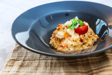 Tasty risotto with Scallops, fresh herbs vegetables on a white plate
