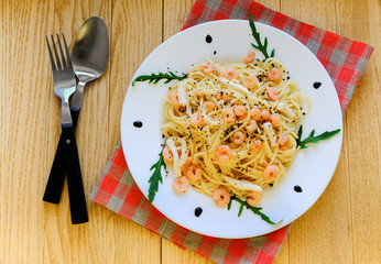 Pasta with prawns and squid meat on a white plate