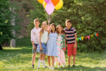 holidays, childhood and celebration concept - happy kids with balloons on birthday party at summer...