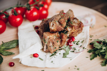 Grilled meat with fresh herbs, vegetables  on rustic wooden board