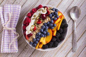 Healthy breakfast bowl - berries, muesli, fruits, yogurt and sunflower seeds. Healthy detox morning meal. View from above, top studio shot
