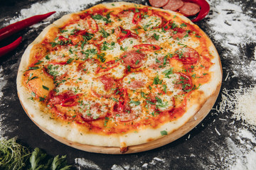 Food ingredients and spices for cooking  delicious italian pizza in a black concrete background. Copyspace Top view Banner.