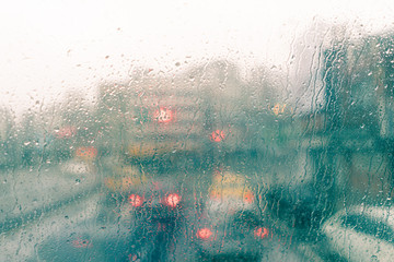 Rain in the big city, looking through the glass filled with rain drops.