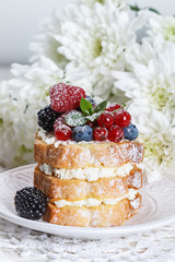 Homemade cake with ricotta and fresh berries-raspberries, red currants, blueberries and blackberries with mint and powdered sugar