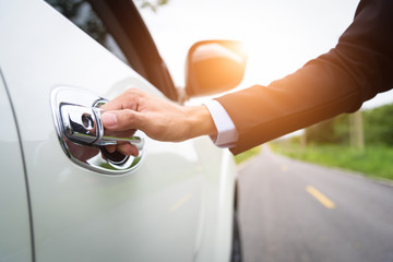 Business men are opening the car door to go to work in the morning.